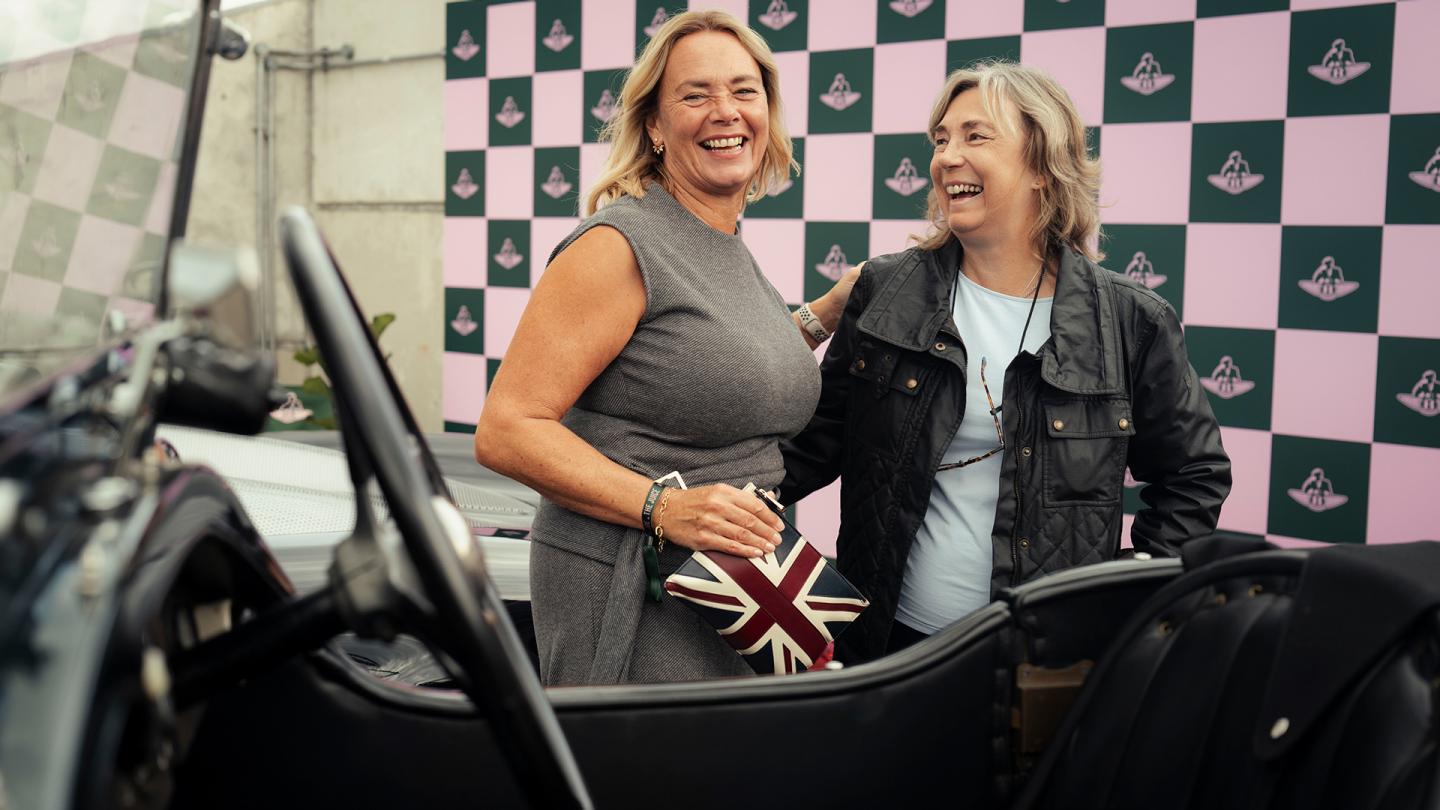 two women standing in front of Bentley Blower heritage car